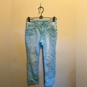 Justice, girls youth light blue skinny jeans with snap button and heart details.